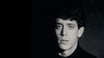 Movie still from “The Velvet Underground” (2021), directed by Todd Haynes – A black and white photo of a young man; Close Up shot, Low angle