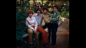 Movie still from “The Velvet Underground” (2021), directed by Todd Haynes – A group of people that are standing in the grass; Medium shot, High angle