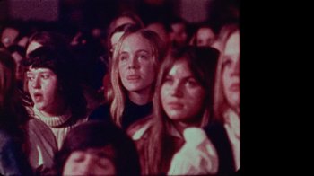 Movie still from “The Velvet Underground” (2021), directed by Todd Haynes – A group of people in a room watching something; Close Up shot, Low angle