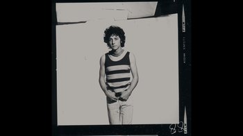 Movie still from “The Velvet Underground” (2021), directed by Todd Haynes – Black and white photograph of a man in striped tank top; Medium shot, Low angle