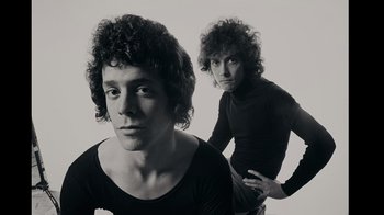 Movie still from “The Velvet Underground” (2021), directed by Todd Haynes – Two men posing for a picture in a black and white photo; Close Up shot, Low angle