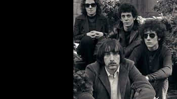 Movie still from “The Velvet Underground” (2021), directed by Todd Haynes – A black and white photo of a man and two women; Medium shot, Low angle