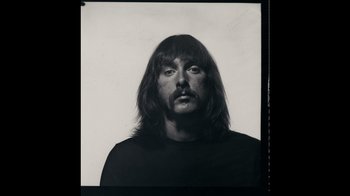 Movie still from “The Velvet Underground” (2021), directed by Todd Haynes – Black and white photograph of a man with long hair; Close Up shot, Overhead angle