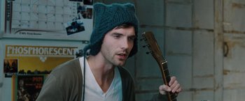 Movie still from “The Vow” (2012), directed by Michael Sucsy – A man wearing a hat and holding a guitar; Close Up shot, Over the shoulder angle