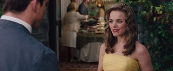 Movie still from “The Vow” (2012), directed by Michael Sucsy – A beautiful young lady in a yellow dress in front of a buffet; Close Up shot, Over the shoulder angle