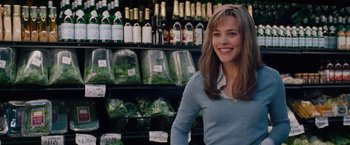 Movie still from “The Vow” (2012), directed by Michael Sucsy – A woman standing in front of a display case filled with bottles of wine; Close Up shot, Over the shoulder angle