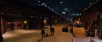 A group of people walking down a street at night