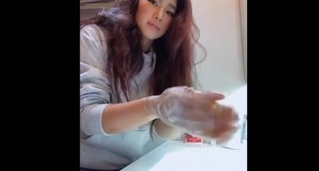 Movie still from “The Wall: Climb for Gold” (2022), directed by Nick Hardie – A woman in white shirt and white gloves sitting at a table; Close Up shot, High angle