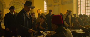 Movie still from “The Water Diviner” (2014), directed by Russell Crowe – A group of people standing in a room; Medium shot, Over the shoulder angle