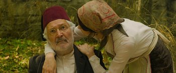 Movie still from “The Water Diviner” (2014), directed by Russell Crowe – An older man and a younger woman are fixing each other's hat; Close Up shot, Over the shoulder angle