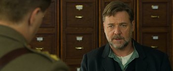 Movie still from “The Water Diviner” (2014), directed by Russell Crowe – A person wearing a suit and tie; Close Up shot, Over the shoulder angle