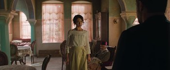 Movie still from “The Water Diviner” (2014), directed by Russell Crowe – A woman standing in front of an older man in a room; Wide shot, Over the shoulder angle