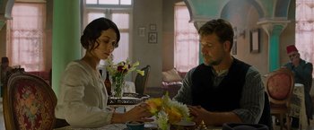 Movie still from “The Water Diviner” (2014), directed by Russell Crowe – A man and a woman sitting at a dining room table; Medium shot, Over the shoulder angle