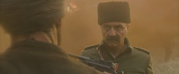 Movie still from “The Water Diviner” (2014), directed by Russell Crowe – A man in a military uniform holding a gun; Close Up shot, Over the shoulder angle