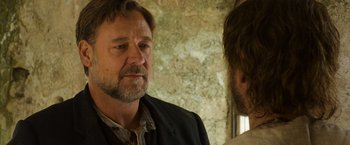 Movie still from “The Water Diviner” (2014), directed by Russell Crowe – A man standing next to another man in front of a brick wall; Close Up shot, Over the shoulder angle