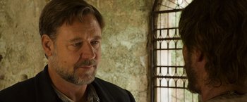 Movie still from “The Water Diviner” (2014), directed by Russell Crowe – A person wearing a jacket near a window; Close Up shot, Over the shoulder angle