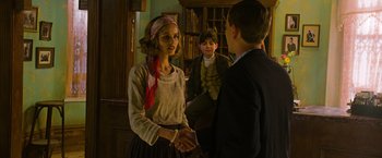Movie still from “The Water Diviner” (2014), directed by Russell Crowe – A woman and two boys shaking hands in a room; Medium shot, Over the shoulder angle