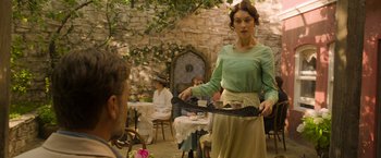 Movie still from “The Water Diviner” (2014), directed by Russell Crowe – A woman in a green shirt holding a knife in front of a man in a green shirt; Medium shot, Over the shoulder angle