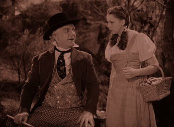 Movie still from “The Wizard of Oz” (1939), directed by Victor Fleming – An older man and a young woman are talking to each other; Medium shot, Low angle