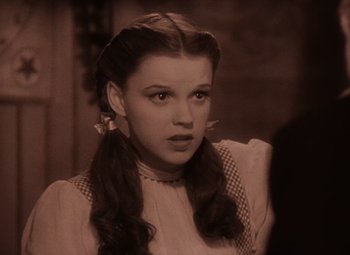 Movie still from “The Wizard of Oz” (1939), directed by Victor Fleming – A woman with long hair and a bow in her hair; Close Up shot, High angle