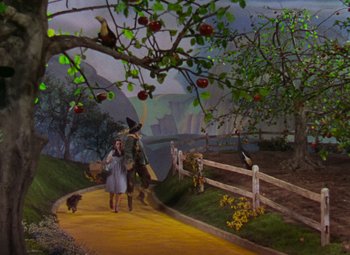 Movie still from “The Wizard of Oz” (1939), directed by Victor Fleming – The wizard of oz painting of scarecrow , dorothy , and the dog; Wide shot, High angle