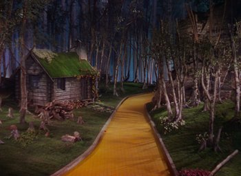 Movie still from “The Wizard of Oz” (1939), directed by Victor Fleming – A yellow brick road leading to a house in the middle of the forest; Extreme Wide shot, High angle