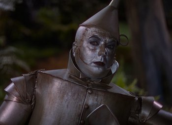 Movie still from “The Wizard of Oz” (1939), directed by Victor Fleming – The tin man from the wizard of oz is dressed in costume; Close Up shot, Low angle