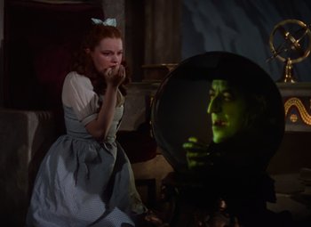 Movie still from “The Wizard of Oz” (1939), directed by Victor Fleming – A woman in a dress looking in a mirror; Medium shot, Low angle