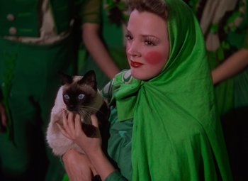 Movie still from “The Wizard of Oz” (1939), directed by Victor Fleming – A woman holding a siamese cat in her arms; Medium shot, Low angle