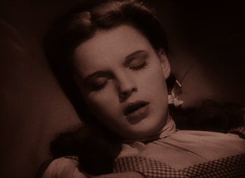 Movie still from “The Wizard of Oz” (1939), directed by Victor Fleming – A woman sleeping on top of a couch; Close Up shot, High angle