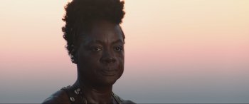 Movie still from “The Woman King” (2022), directed by Gina Prince-Bythewood – A person with a bun on their head; Close Up shot, Low angle