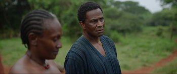 Movie still from “The Woman King” (2022), directed by Gina Prince-Bythewood – A person wearing a blue shirt; Close Up shot, Over the shoulder angle