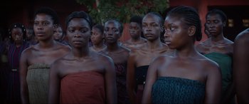 Movie still from “The Woman King” (2022), directed by Gina Prince-Bythewood – A group of women standing next to each other in front of a tree; Close Up shot, Over the shoulder angle
