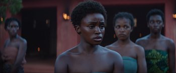Movie still from “The Woman King” (2022), directed by Gina Prince-Bythewood – Two women standing next to each other in front of a building; Close Up shot, Over the shoulder angle