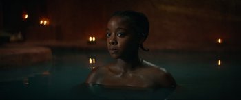 Movie still from “The Woman King” (2022), directed by Gina Prince-Bythewood – A woman sitting in a pool of water; Close Up shot, Over the shoulder angle