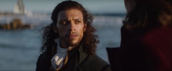 Movie still from “The Woman King” (2022), directed by Gina Prince-Bythewood – A person with long curly hair; Close Up shot, Over the shoulder angle