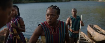 Movie still from “The Woman King” (2022), directed by Gina Prince-Bythewood – A man and a woman standing next to a body of water; Medium shot, Over the shoulder angle