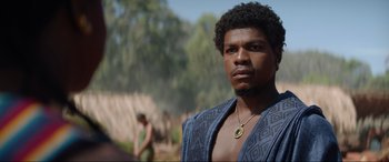 Movie still from “The Woman King” (2022), directed by Gina Prince-Bythewood – A black man with a beard and a necklace; Close Up shot, Low angle