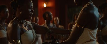 Movie still from “The Woman King” (2022), directed by Gina Prince-Bythewood – A woman is holding a knife in her hand; Close Up shot, Over the shoulder angle