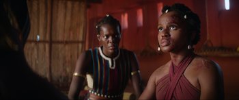 Movie still from “The Woman King” (2022), directed by Gina Prince-Bythewood – A couple of women standing next to each other in a room; Close Up shot, Low angle