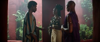 Movie still from “The Woman King” (2022), directed by Gina Prince-Bythewood – A group of people standing next to each other in a room; Medium shot, Over the shoulder angle