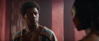 Movie still from “The Woman King” (2022), directed by Gina Prince-Bythewood – A person wearing a sweater; Close Up shot, Low angle