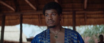 Movie still from “The Woman King” (2022), directed by Gina Prince-Bythewood – A person wearing a blue and gold shirt; Close Up shot, Low angle