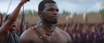 Movie still from “The Woman King” (2022), directed by Gina Prince-Bythewood – A person wearing a necklace; Close Up shot, Low angle