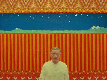 Movie still from “The Wonderful Story of Henry Sugar” (2023), directed by Wes Anderson – An older man standing in front of a painting; Medium shot, Low angle