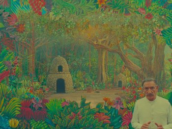Movie still from “The Wonderful Story of Henry Sugar” (2023), directed by Wes Anderson – A man standing in front of a painting of trees and flowers; Wide shot, Low angle