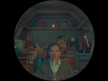 Movie still from “The Wonderful Story of Henry Sugar” (2023), directed by Wes Anderson – A man is sitting in front of a camera; Medium shot, Overhead angle