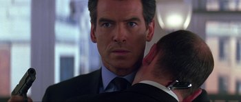 Movie still from “The World Is Not Enough” (1999), directed by Michael Apted – A man in a suit and tie looking at a man in a suit and tie; Close Up shot, Over the shoulder angle