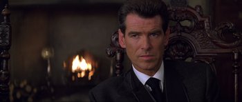 Movie still from “The World Is Not Enough” (1999), directed by Michael Apted – A person wearing a suit and tie; Close Up shot, Over the shoulder angle