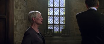 Movie still from “The World Is Not Enough” (1999), directed by Michael Apted – A woman standing in front of a stained glass window; Medium shot, Over the shoulder angle